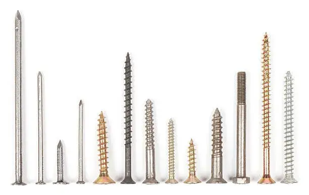 Varios tornillos metálicos alineados sobre fondo blanco, ideales para observar las características de tornillos para concreto vs tornillos para madera.