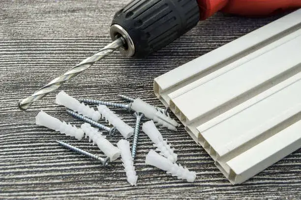 Tornillos, taquetes y martillo sobre mesa clara incluidos como parte del top 5 productos de fijación que todo instalador debe tener en campo.