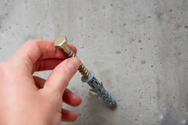 Tornillo atornillado en concreto que evidencia el uso correcto según diferencias en tornillos para concreto vs tornillos para madera.